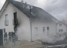 Der erste Trupp bekämpft im Inneren die Flammen, der Sicherungstrupp löscht brennenden Kleinteile um das Gebäude ab.